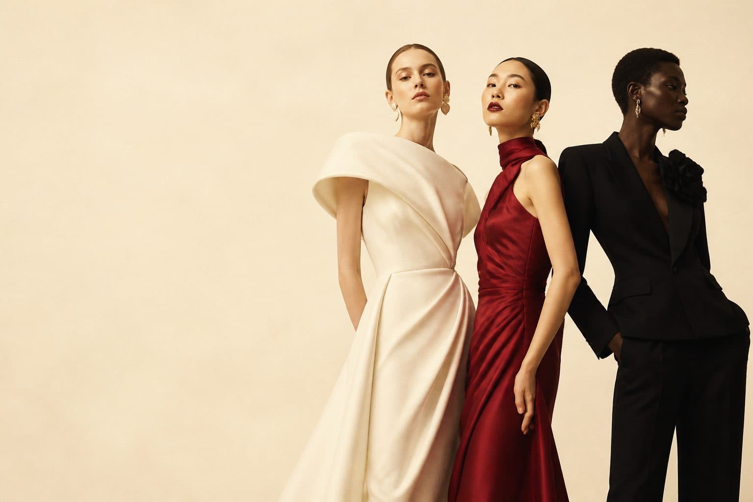 Three AI-generated couture looks: an ivory sculptural gown, a crimson silk dress and a black tailored suit